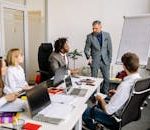 Corporate team in a modern office, engaged in a discussion with diverse colleagues.